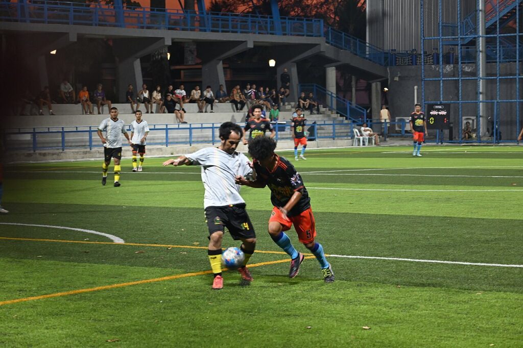File:DFC 5330 Two players battle for possession during an evening soccer match at Klet Kaeo field in Sattahip Chon Buri.jpg — illustrative image
