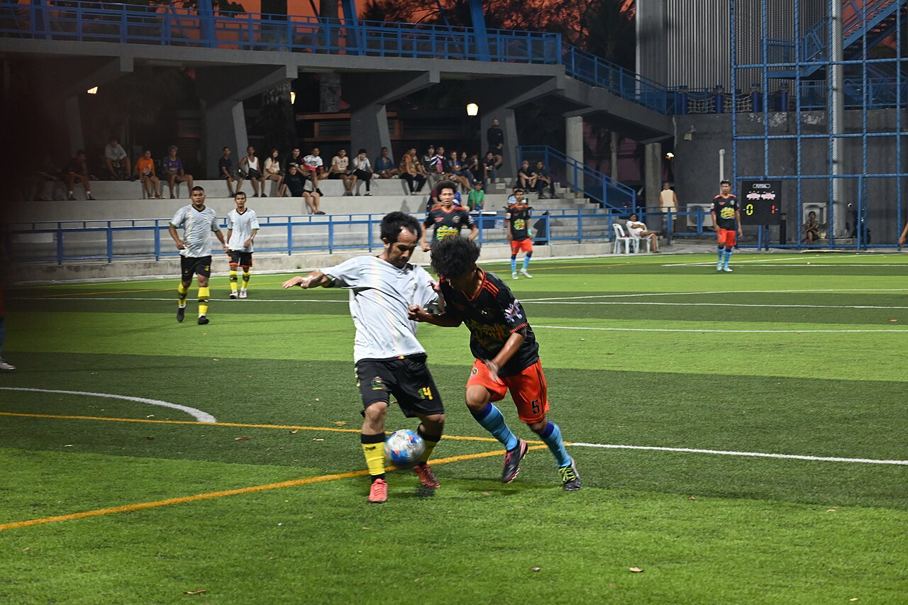 File:DFC 5330 Two players battle for possession during an evening soccer match at Klet Kaeo field in Sattahip Chon Buri.jpg — illustrative image
